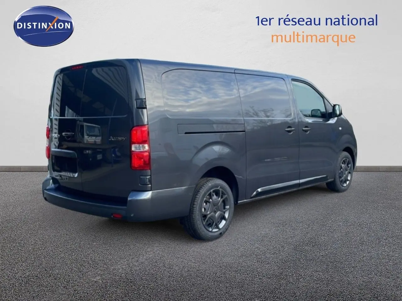 Vue 3/4 arrière droit d’un Citroën Jumpy Van Long L3 gris titane métallisé avec vitres arrière teintées et jantes noires.