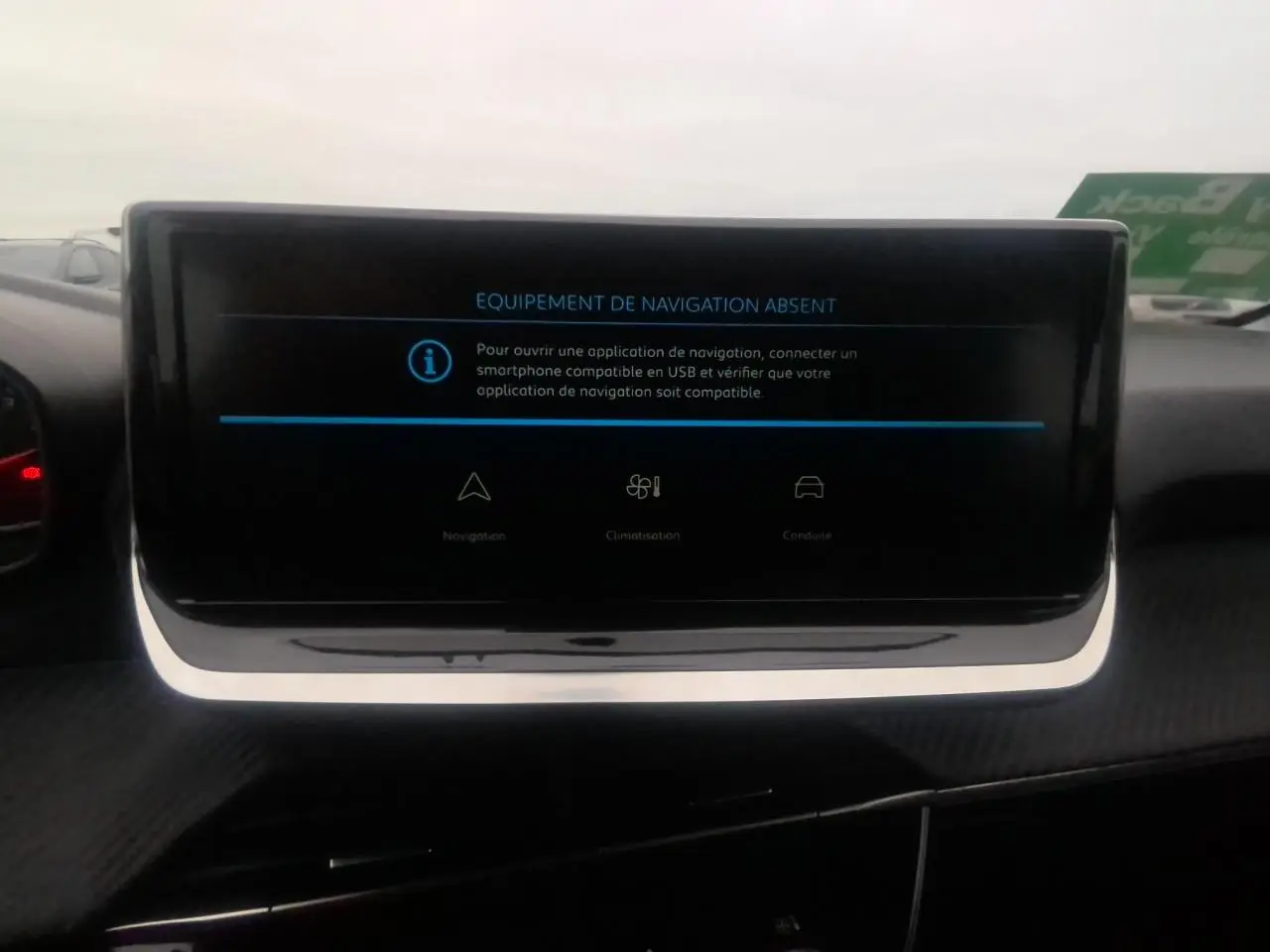 Écran central tactile affichant l'absence d'équipement de navigation dans une Peugeot 208 gris clair, vue intérieure.
