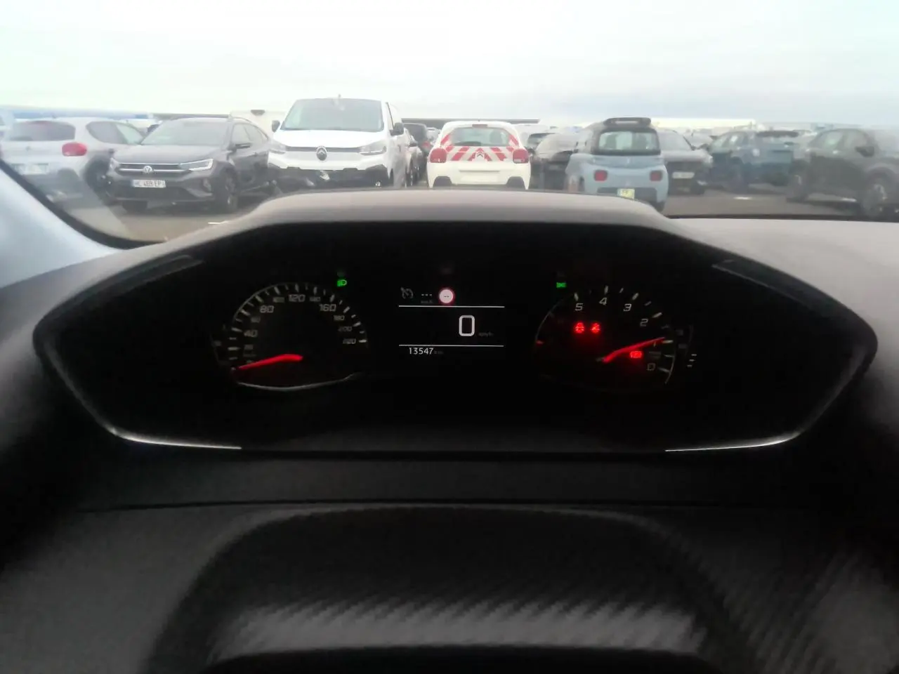 Vue intérieure du tableau de bord de la Peugeot 208 gris clair 2024, affichant le compteur digital à zéro km/h.