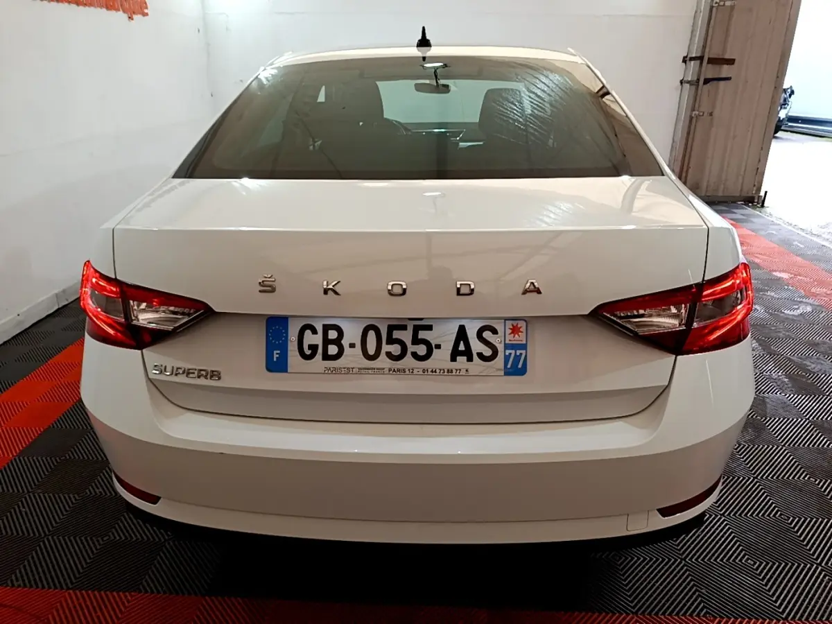 Vue arrière d'une Skoda Superb blanche 2021 avec feux LED et plaque d'immatriculation française visible.
