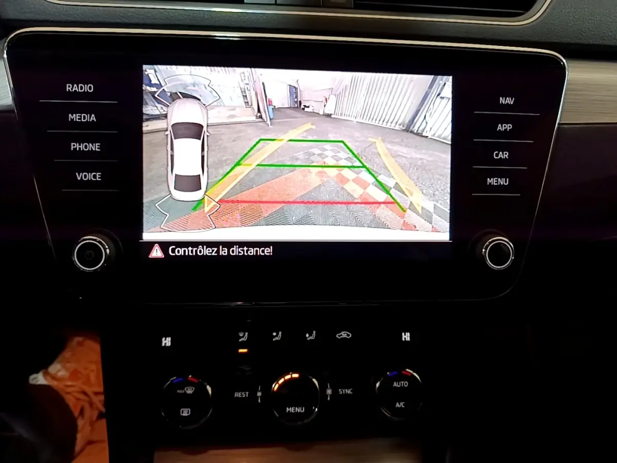 Affichage de la caméra de recul sur écran tactile du tableau de bord d'une Skoda Superb blanche, vue intérieure centrale.