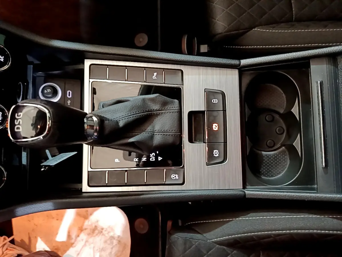 Vue rapprochée de la console centrale noire avec levier de vitesse DSG et porte-gobelets de la Skoda Superb 2021.