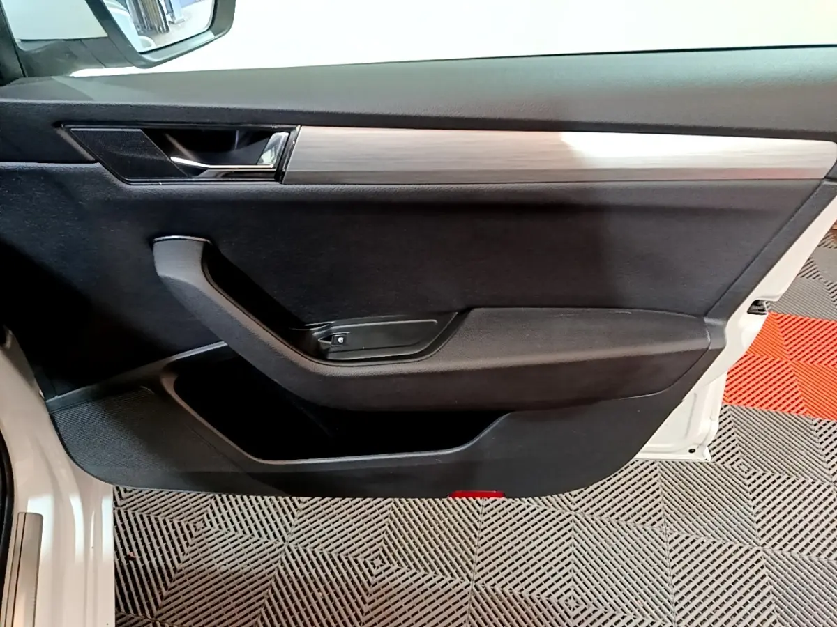 Vue intérieure de la porte avant gauche noire avec insert décoratif bois clair de la Skoda Superb blanche 2021.