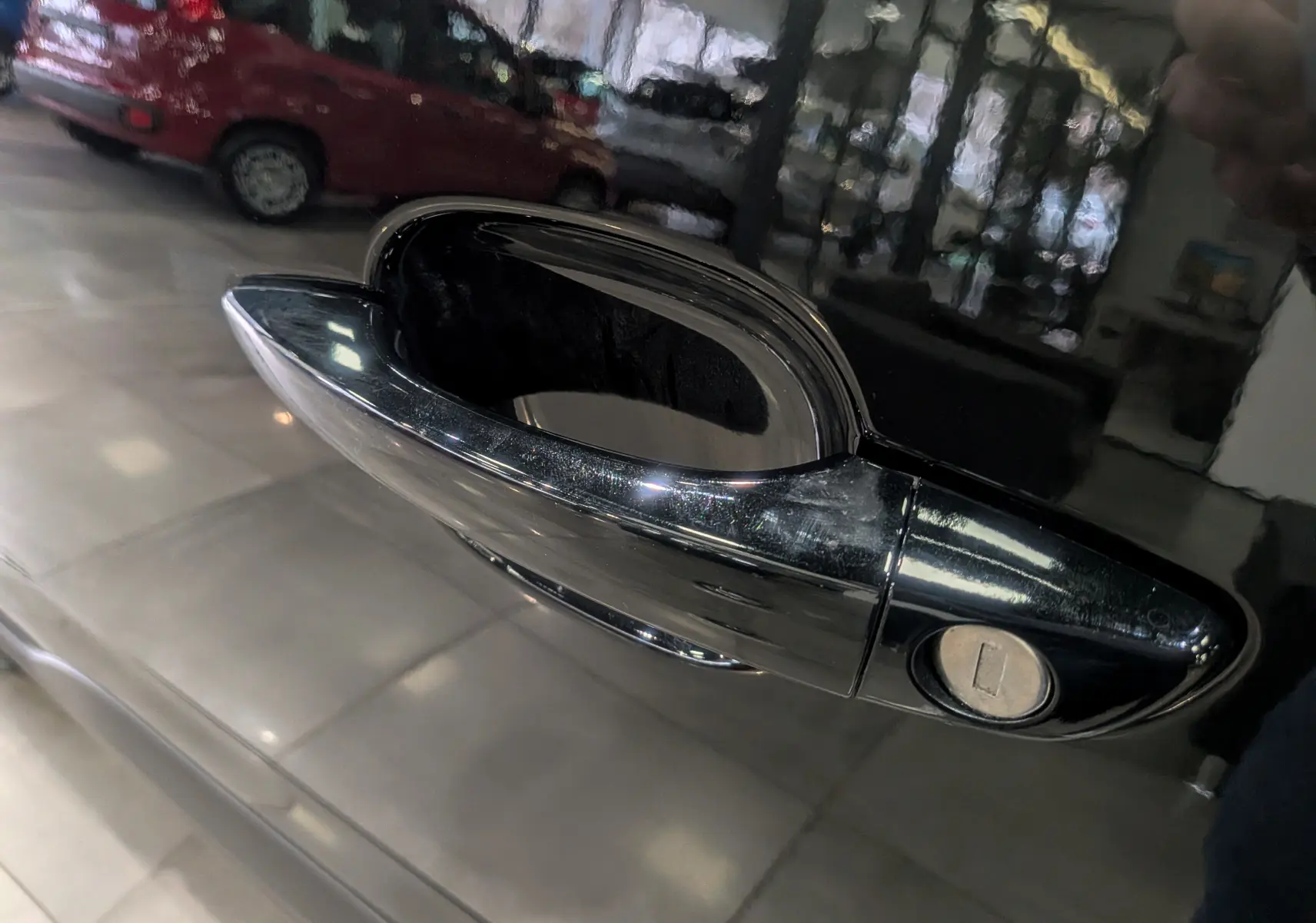 Poignée de porte noire brillante du côté gauche d’un Peugeot Rifter 2025, avec serrure visible en gros plan.