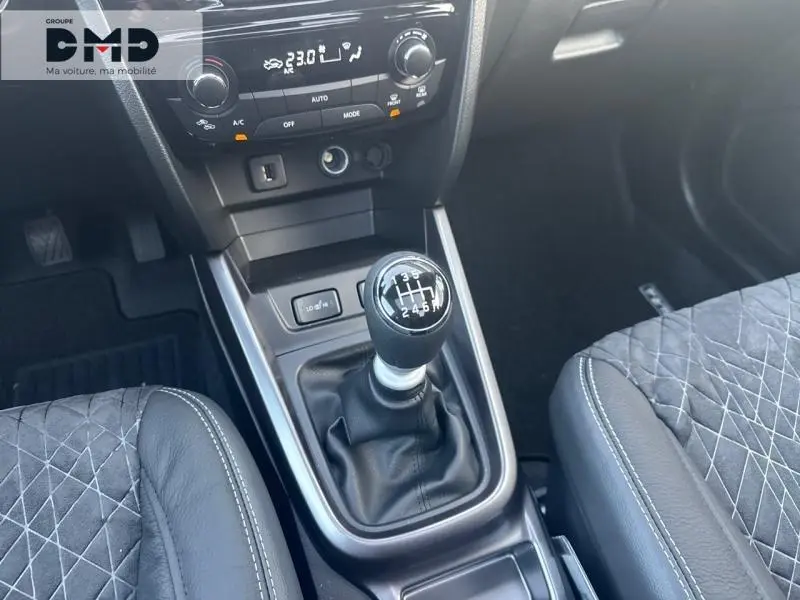 Vue intérieure centrée sur le levier de vitesses manuel du Suzuki Vitara 1.4 Boosterjet Hybrid, sièges en suédine et cuir noir.