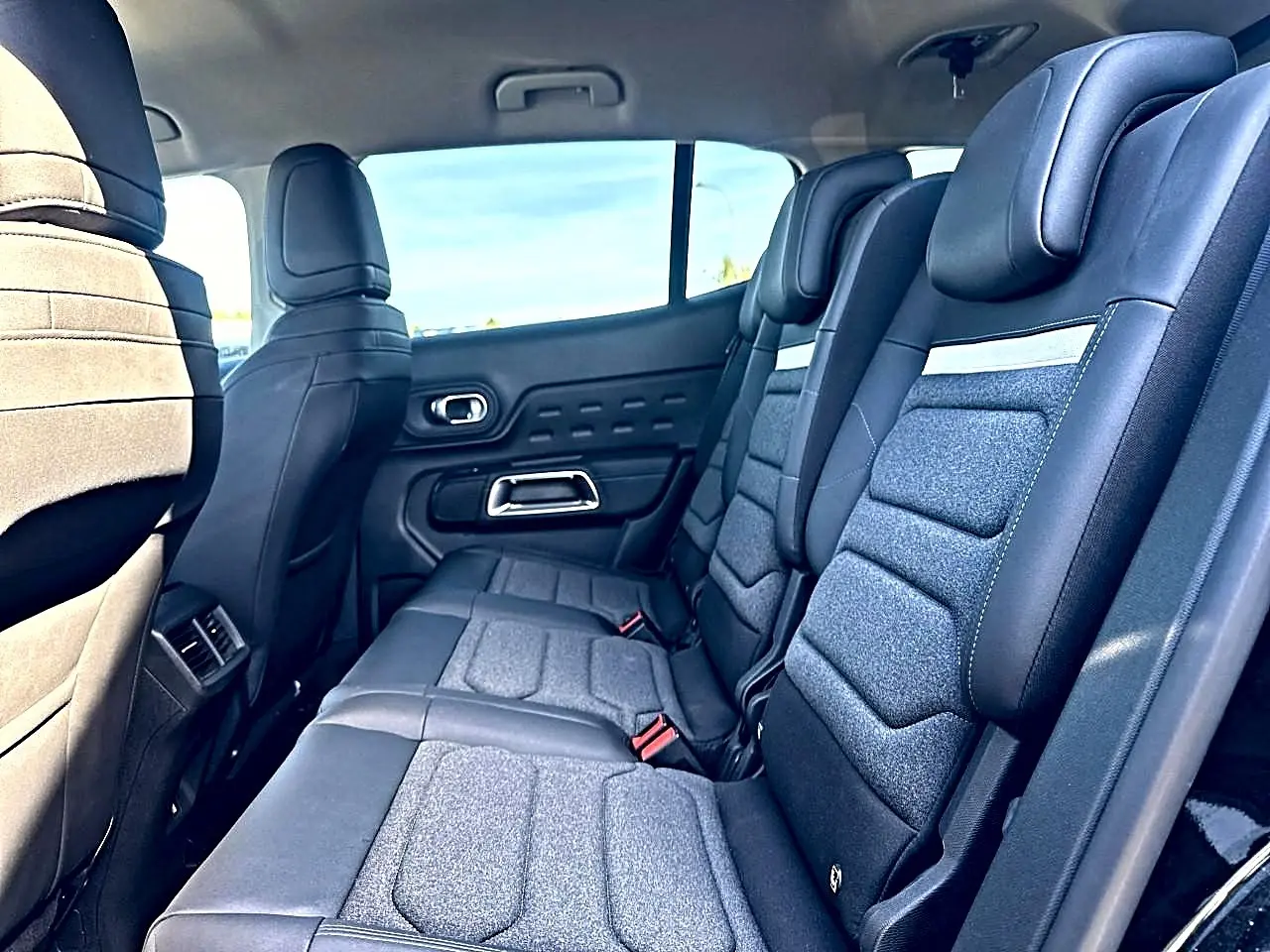 Vue latérale intérieure sur la 2e rangée de sièges individuels noirs et gris du Citroën C5 Aircross 2025.