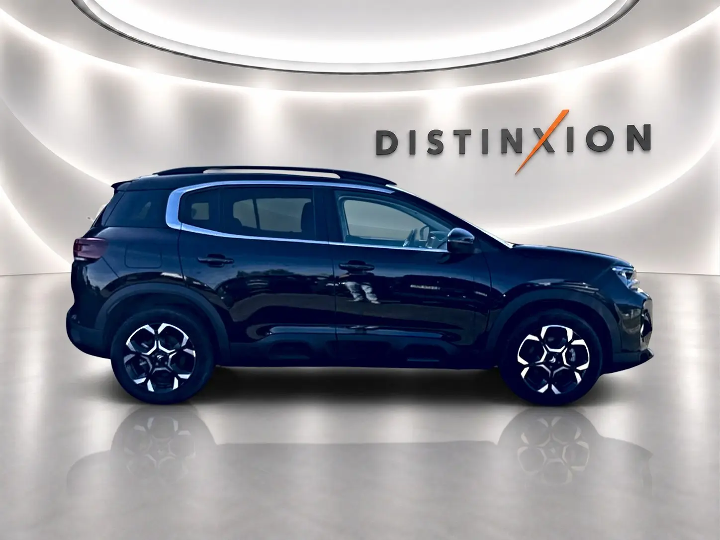 Vue de profil côté gauche d'un Citroën C5 Aircross noir 2025 dans un showroom lumineux avec jantes alu distinctives.