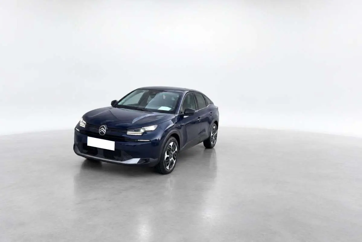 Citroën C4 hybride bleu eclipse vue 3/4 avant droit sur fond neutre, avec phares LED et jantes distinctives.