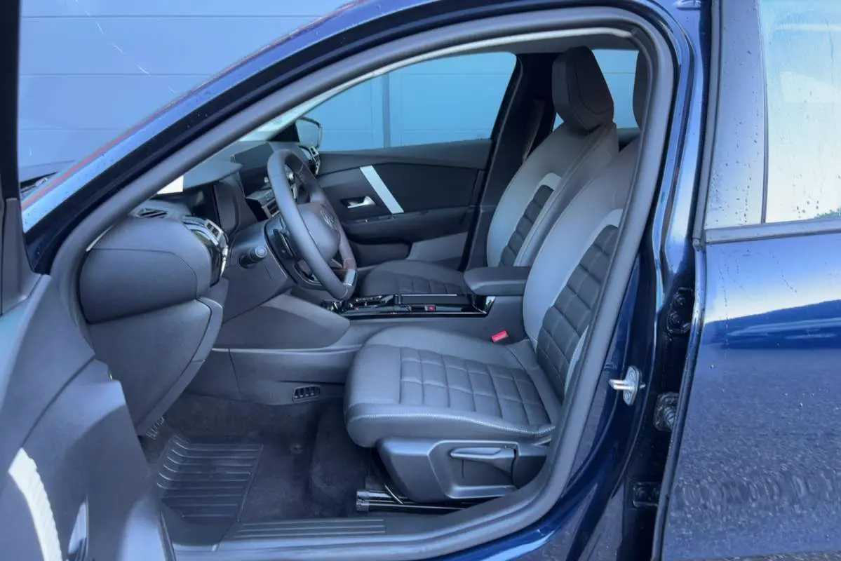 Intérieur avant de la Citroën C4 hybride bleu eclipse, vue côté gauche montrant sièges et tableau de bord modernes.