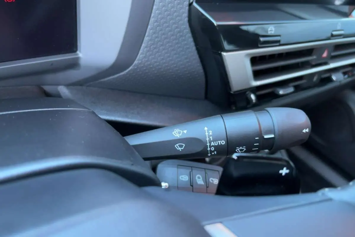 Gros plan sur la commande d’essuie-glace côté droit du tableau de bord d’une Citroën C4 hybride bleu eclipse.