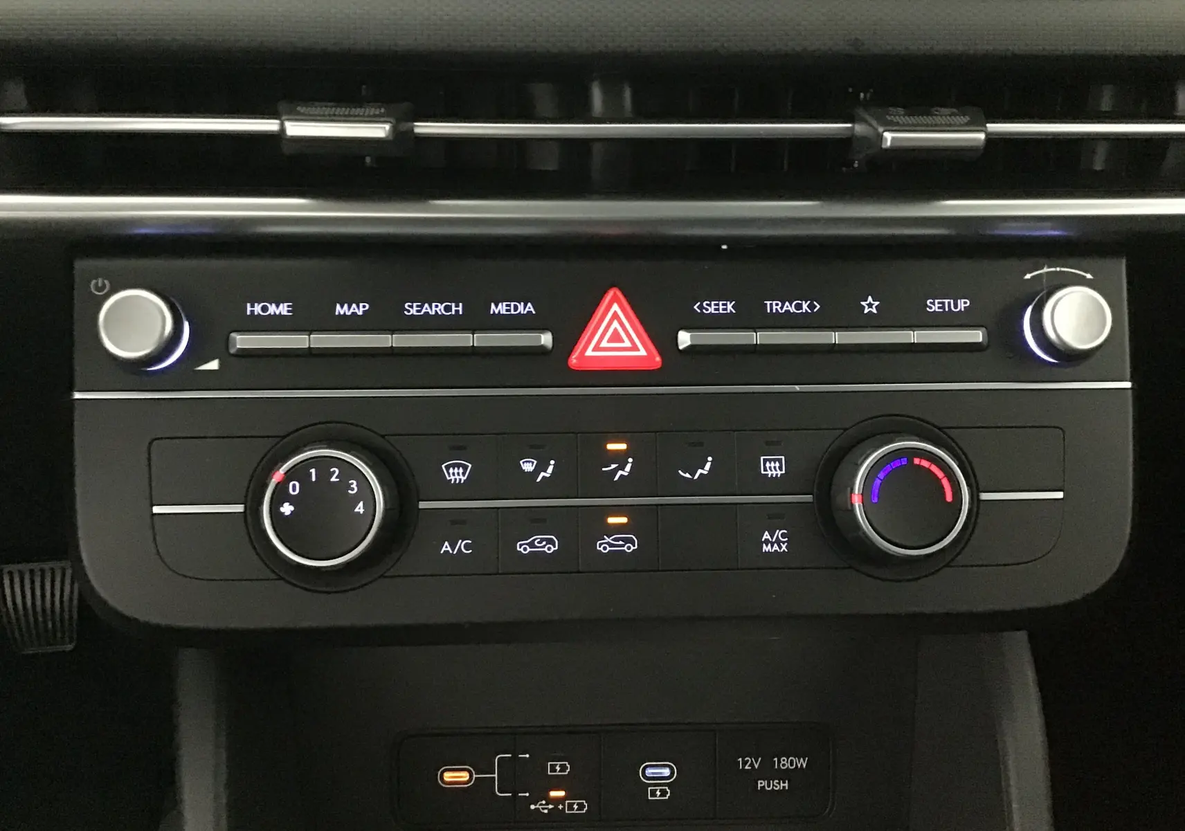 Panneau de commande central du Hyundai Tucson 2025 avec climatisation et boutons média en vue frontale rapprochée.