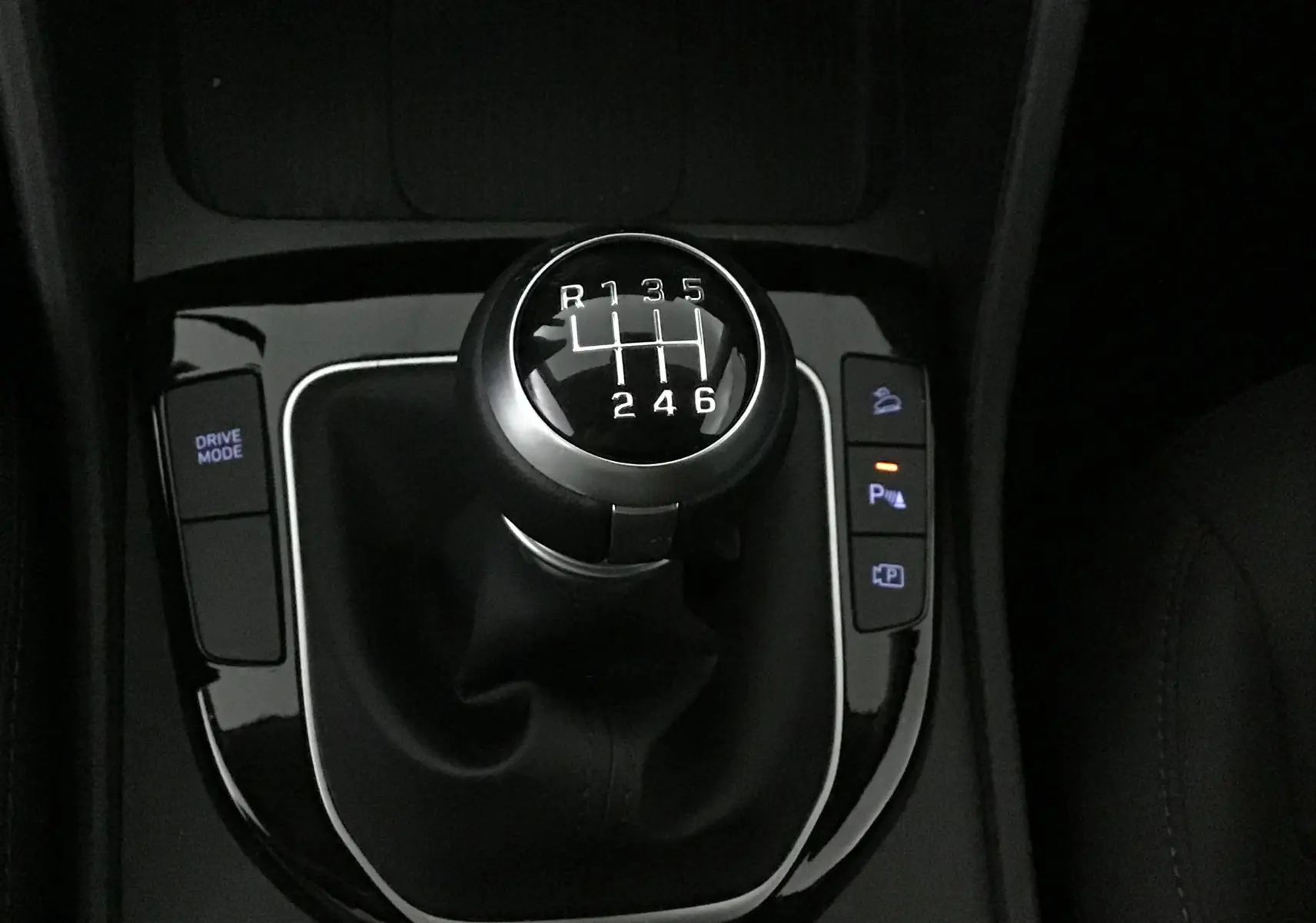 Le levier de vitesse manuel du Hyundai Tucson 2025, vue rapprochée sur la console centrale noire brillante.