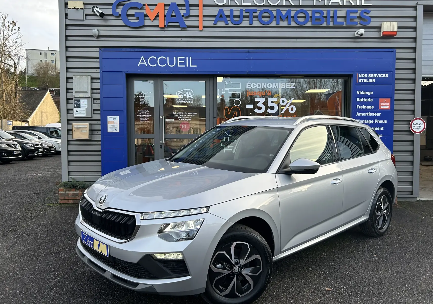 Vue 3/4 avant droite d’un Skoda Kamiq gris argent métallisé 2025, avec calandre noire et jantes au design moderne.