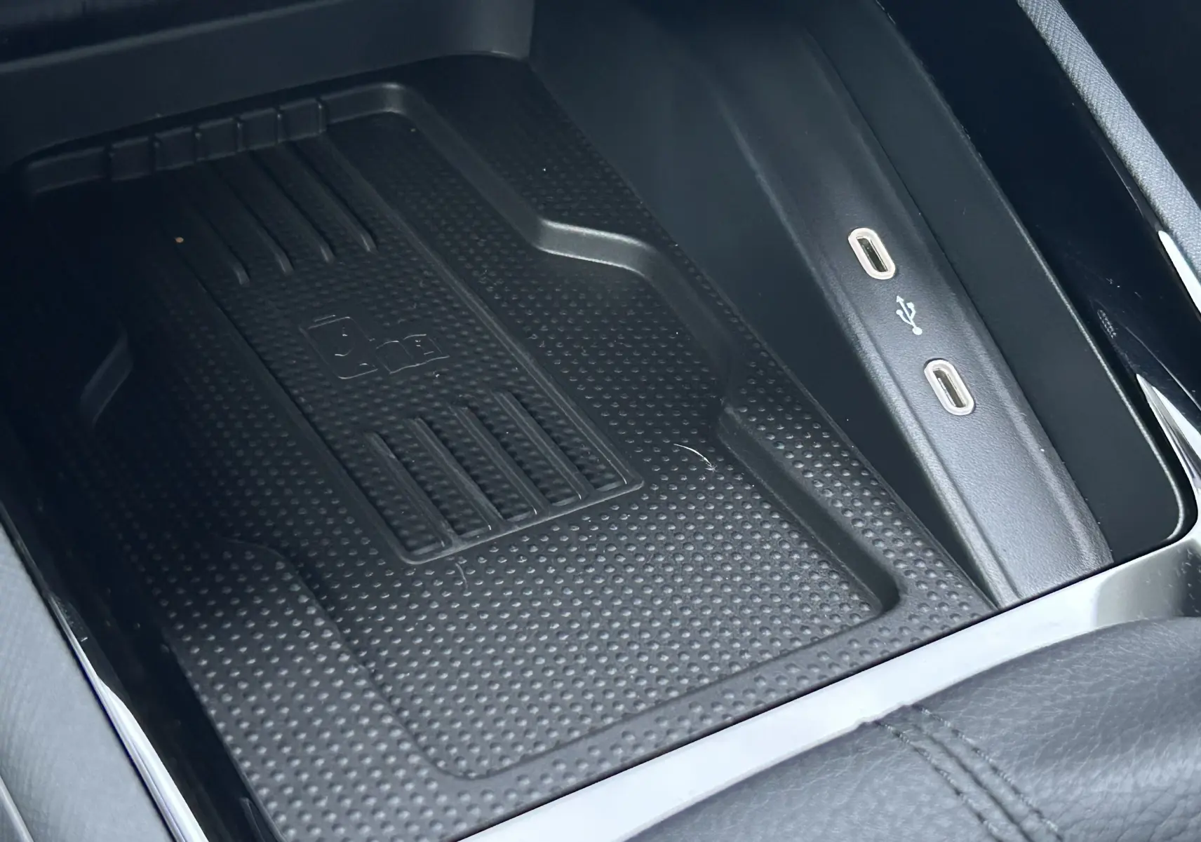 Gros plan sur le chargeur à induction et ports USB-C du Skoda Kamiq gris argent 2025, intérieur noir.