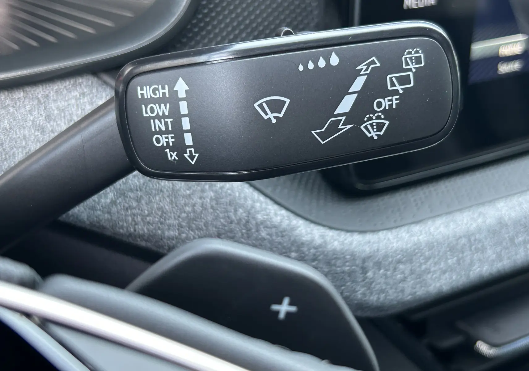 Gros plan sur la manette d’essuie-glace noire dans l’habitacle gris foncé du Skoda Kamiq 2025 gris argent métal.