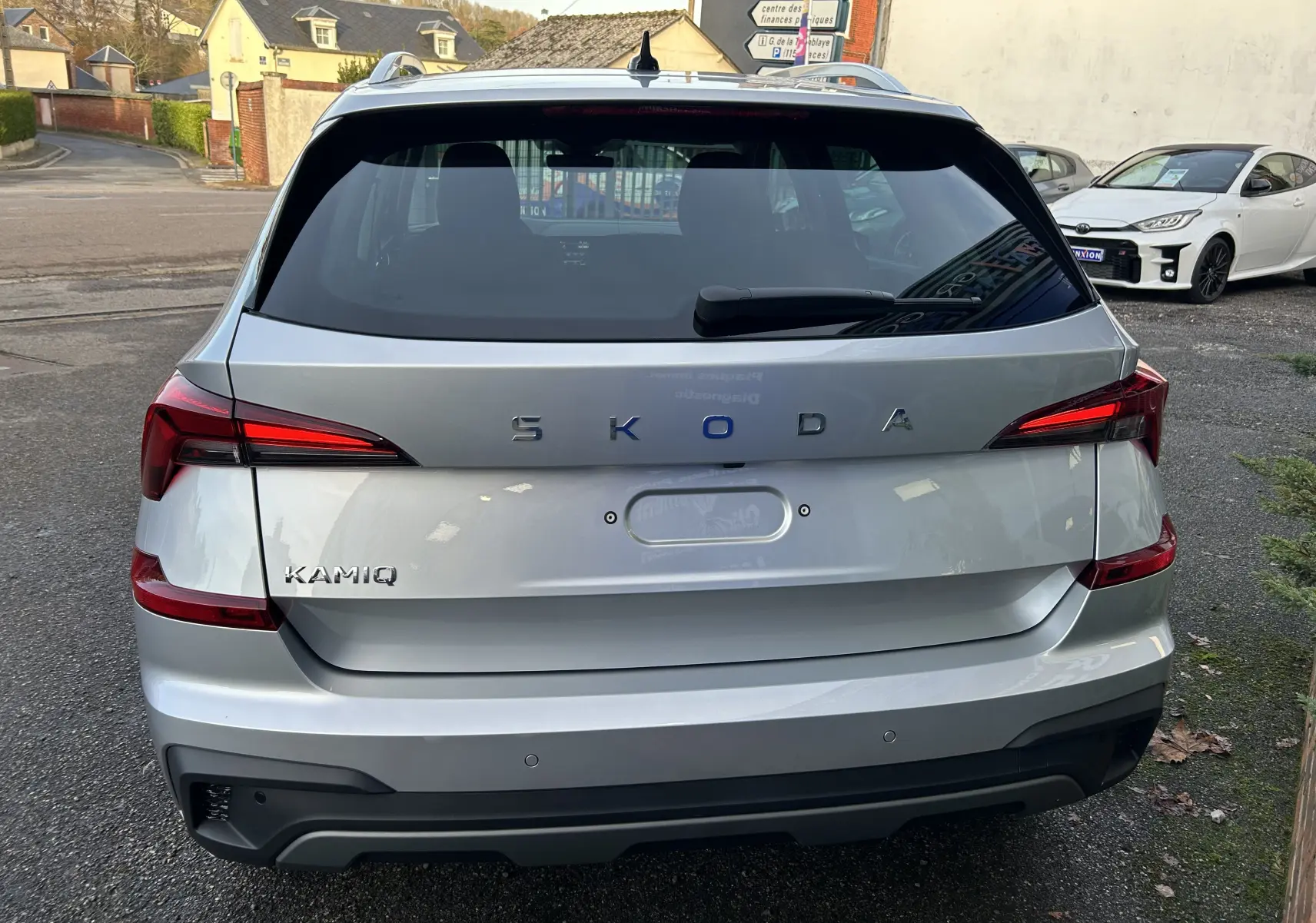 Vue arrière d’un Skoda Kamiq gris argent métal 2025 avec feux LED et caméra de recul visible sur le hayon.