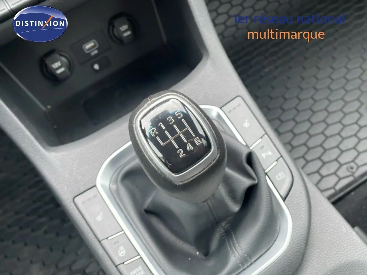 Le levier de vitesses manuel de la Hyundai i30 SW 2023 en gros plan, entouré de commandes et prises USB.
