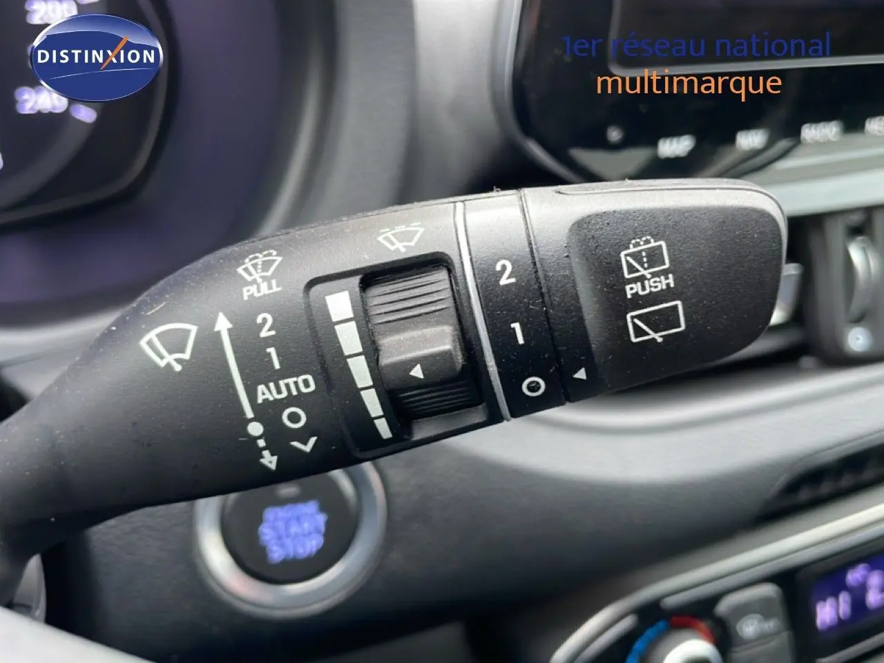 Gros plan sur la commande des essuie-glaces dans l'habitacle d'une Hyundai i30 SW blanche, modèle 2023.