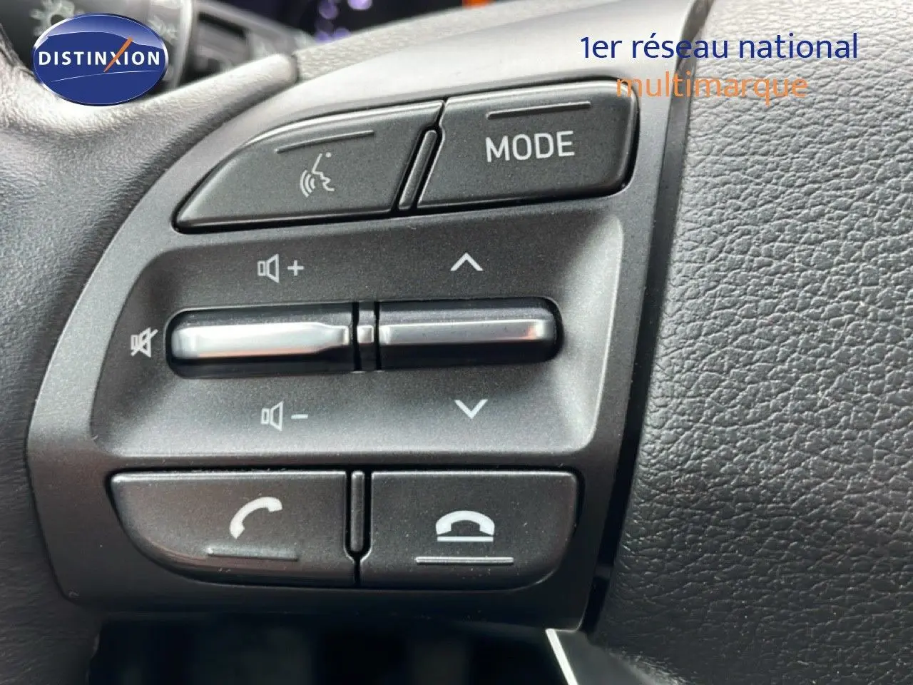 Gros plan sur les commandes multifonctions au volant du Hyundai i30 SW 2023, finition Family Smart, intérieur noir.
