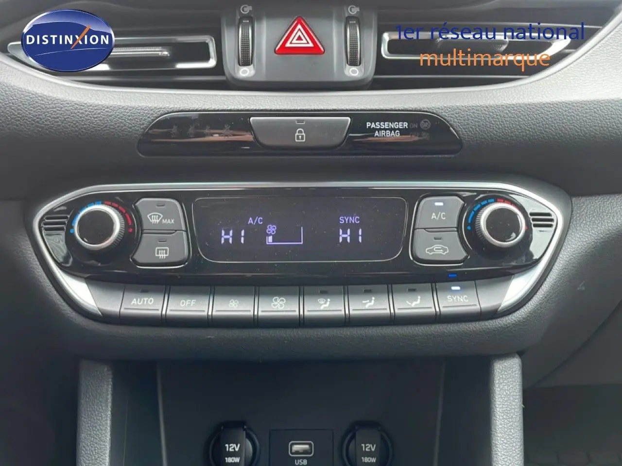 Gros plan sur la console centrale de la Hyundai i30 SW 2023, montrant les commandes de climatisation et ports USB/12V.