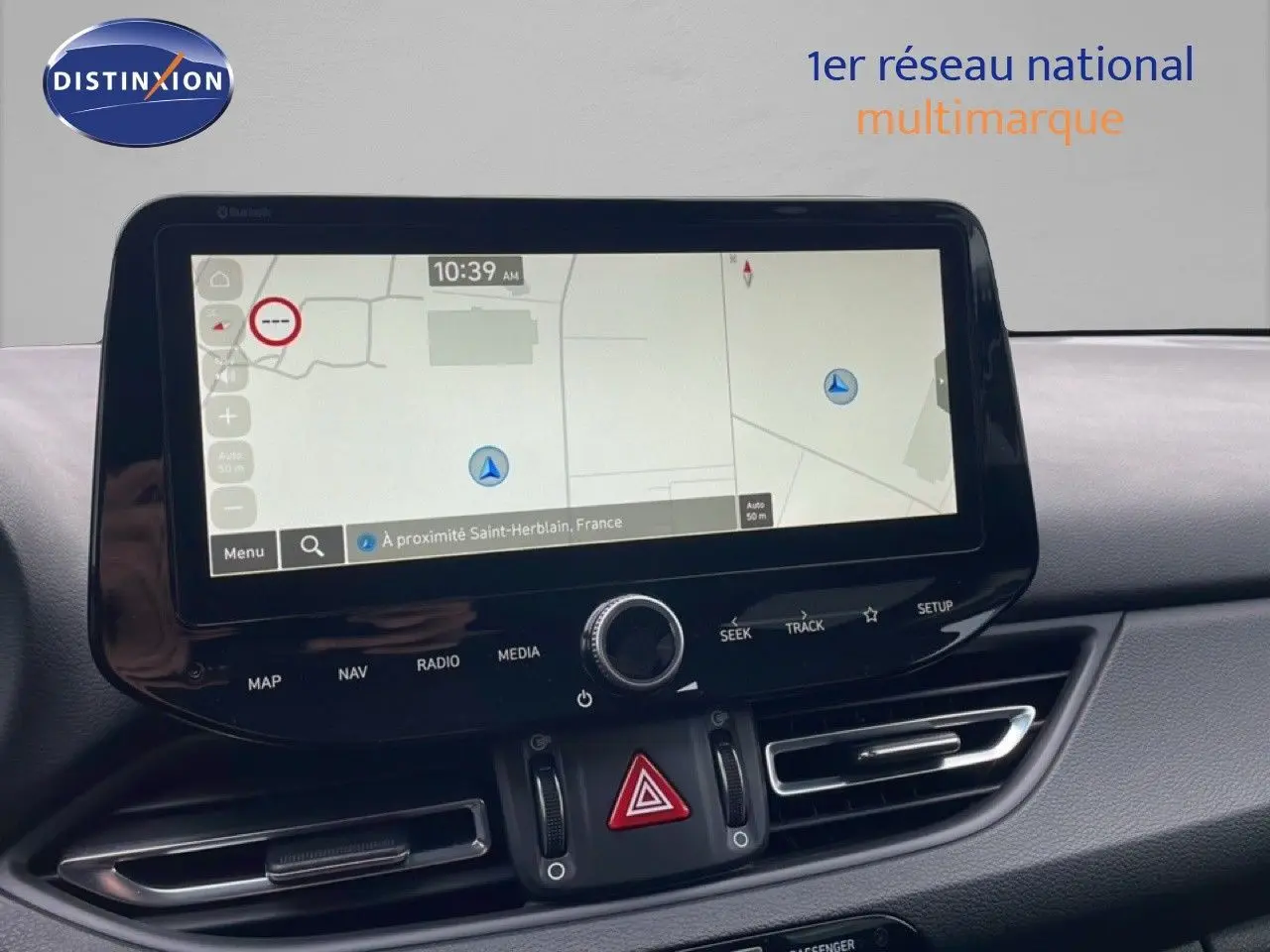 Vue intérieure centrée sur l'écran tactile du système de navigation de la Hyundai i30 SW blanche de 2023.