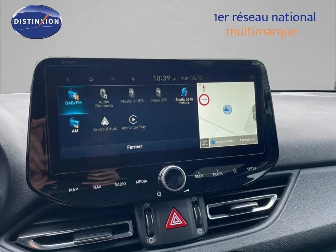 Écran tactile central de la Hyundai i30 SW 2023 affichant navigation et options multimédia, intérieur gris.