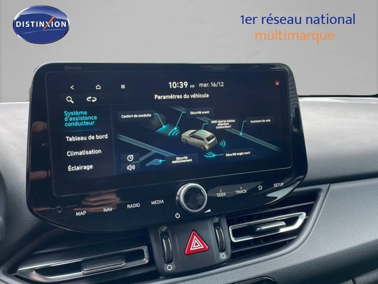 Écran tactile central du tableau de bord de la Hyundai i30 SW blanc Atlas, affichant les paramètres d’assistance conducteur.
