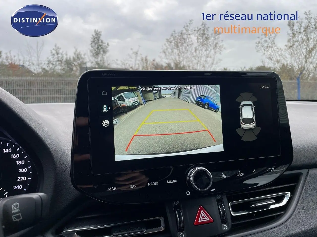 Écran central affichant la caméra de recul avec vue arrière du véhicule, tableau de bord noir moderne Hyundai i30 SW.