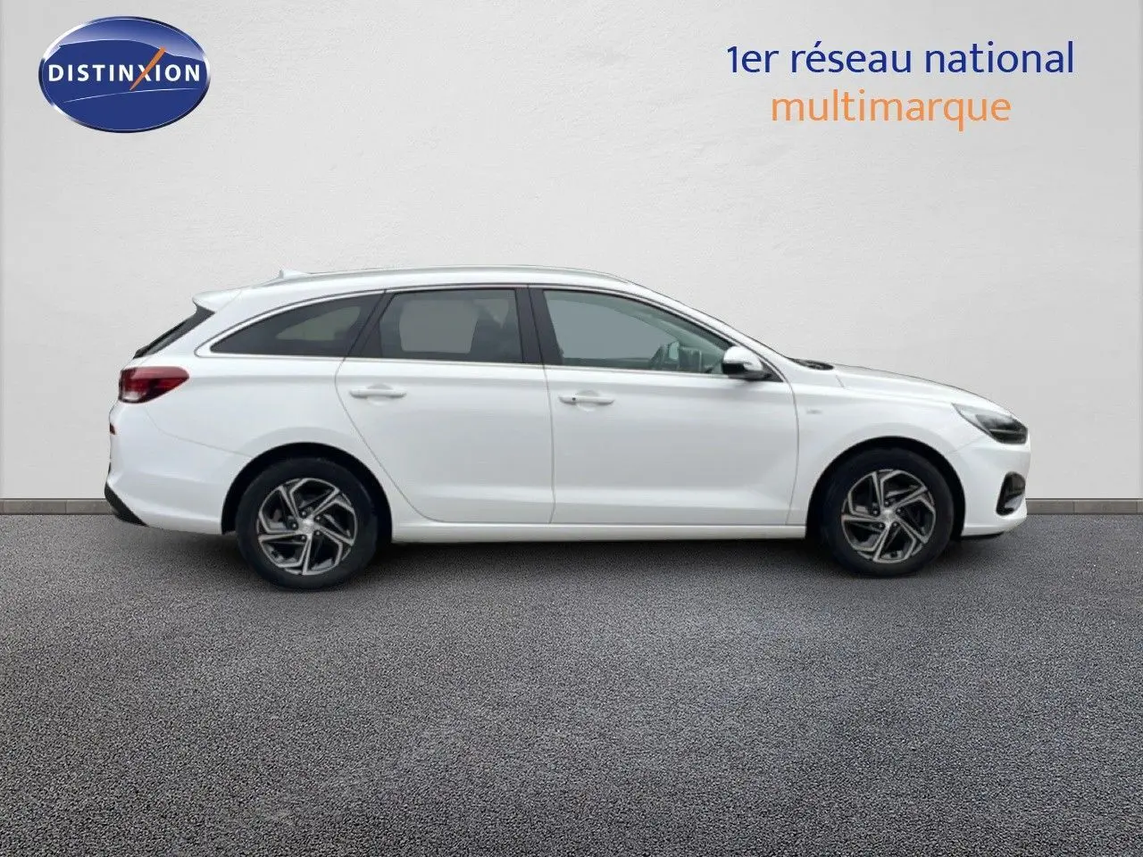 Profil droit d'une Hyundai i30 SW blanche Atlas 2023 avec jantes alliage et lignes épurées.