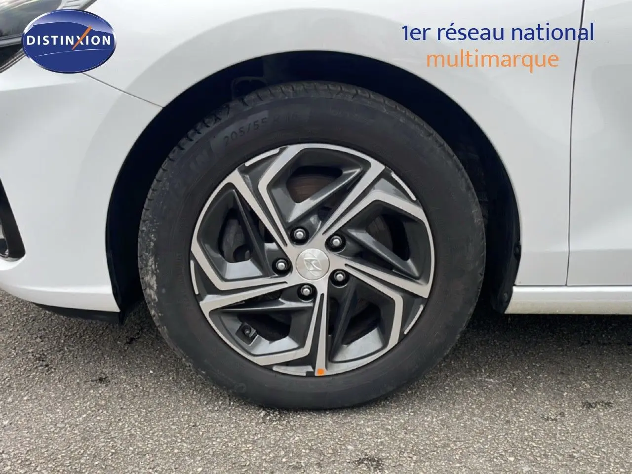 Gros plan sur la roue avant gauche avec jante alliage gris et noir d'une Hyundai i30 SW blanc Atlas.