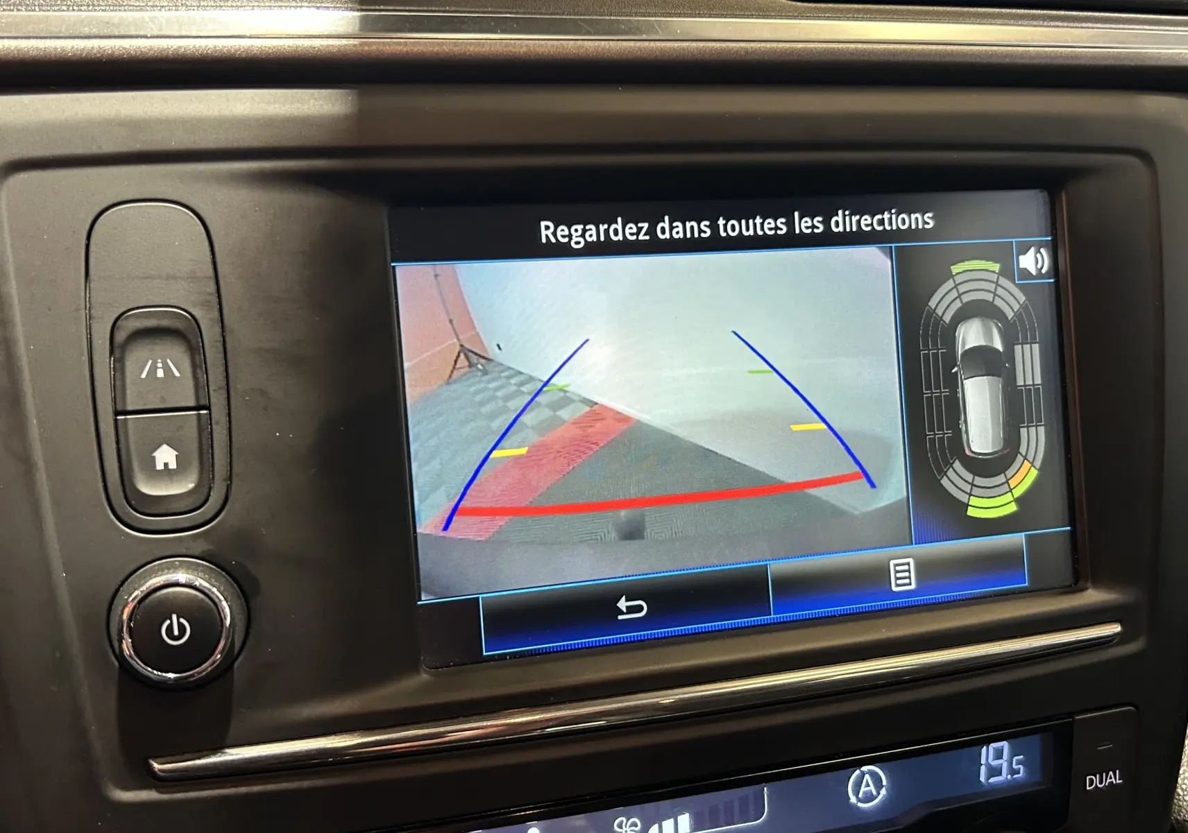 Écran central de Renault Kadjar blanc montrant la caméra de recul avec guidage et capteurs de proximité activés.