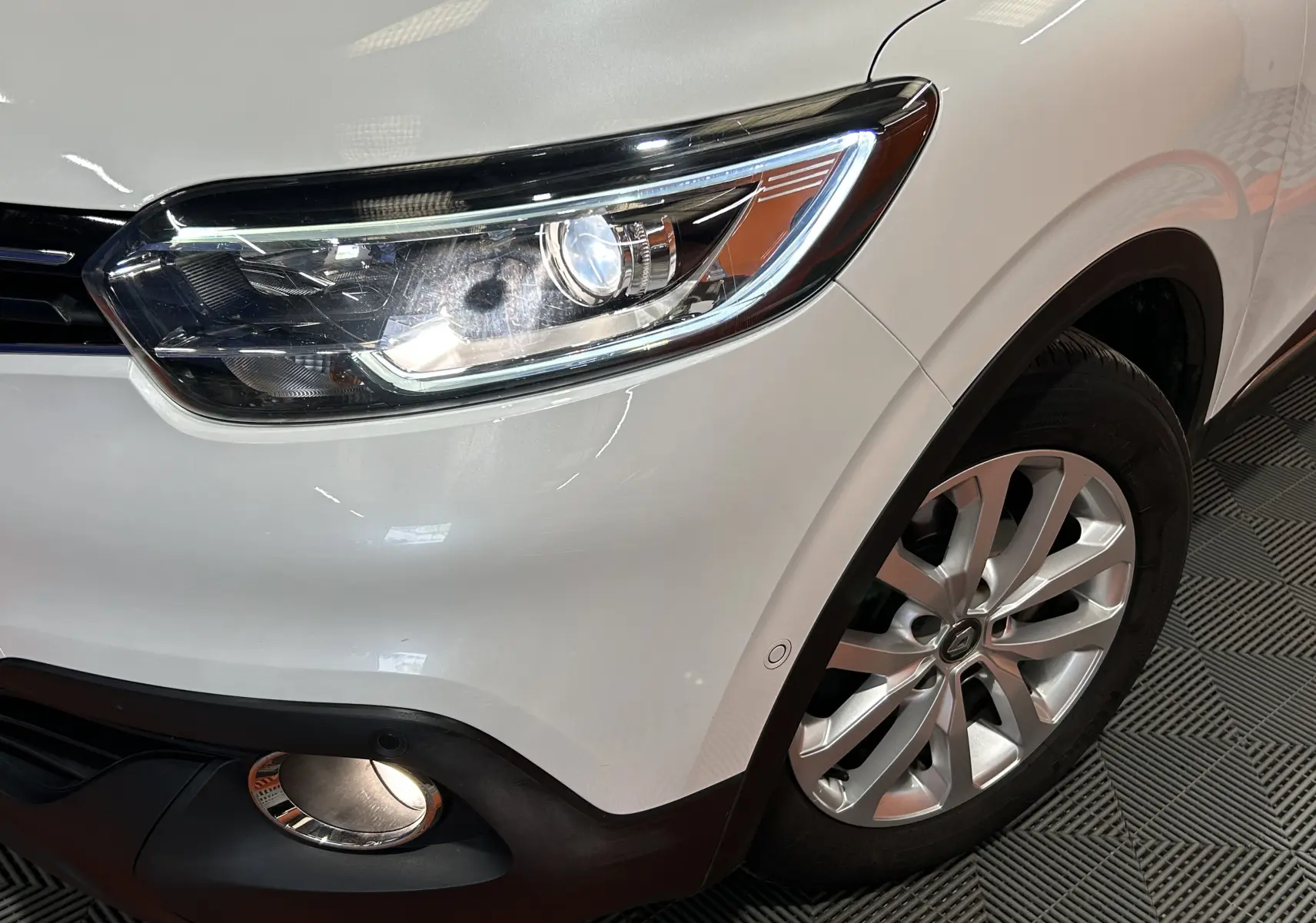Gros plan sur l'avant droit blanc du Renault Kadjar 2018, mettant en valeur le phare et la roue alliage.