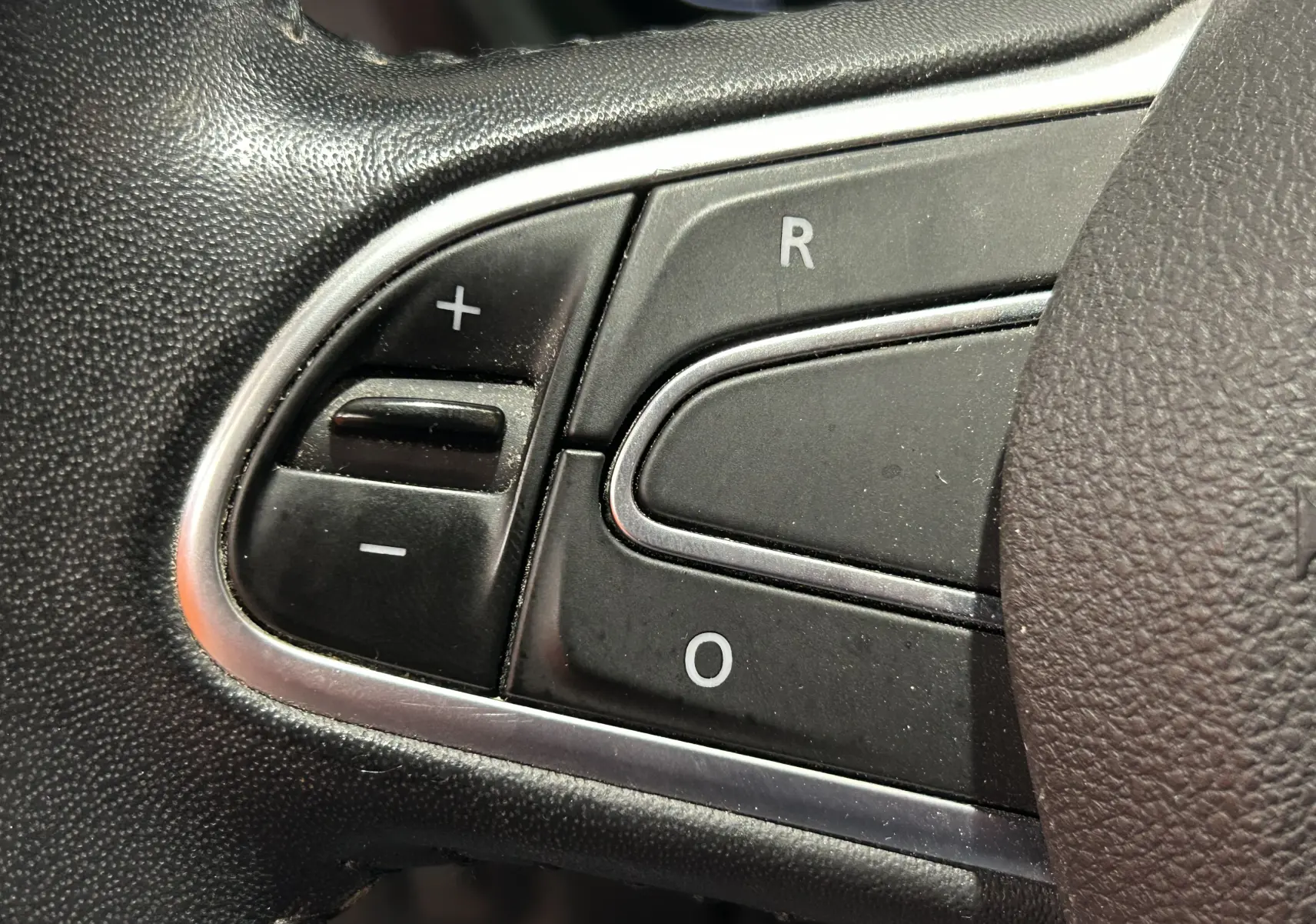 Gros plan sur les commandes de régulateur de vitesse au volant du Renault Kadjar blanc, version TCE 130 ENERGY INTENS EDC.