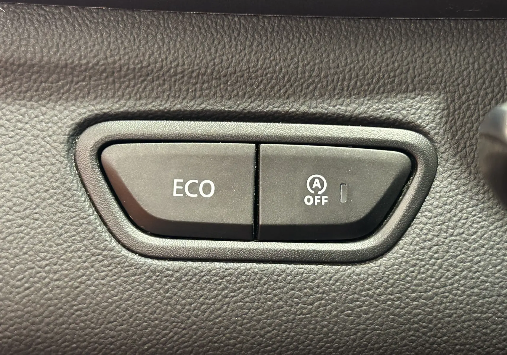Boutons de commande ECO et désactivation du système start-stop sur le tableau de bord du Renault Kadjar blanc.