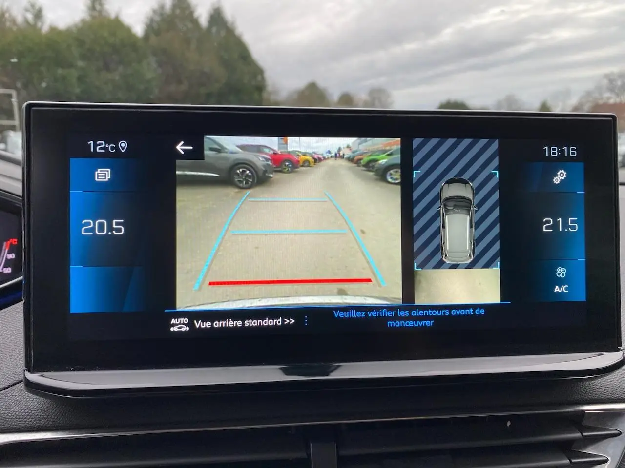 Écran tactile du Peugeot 3008 gris platinium montrant la caméra de recul et l'aide au stationnement arrière.