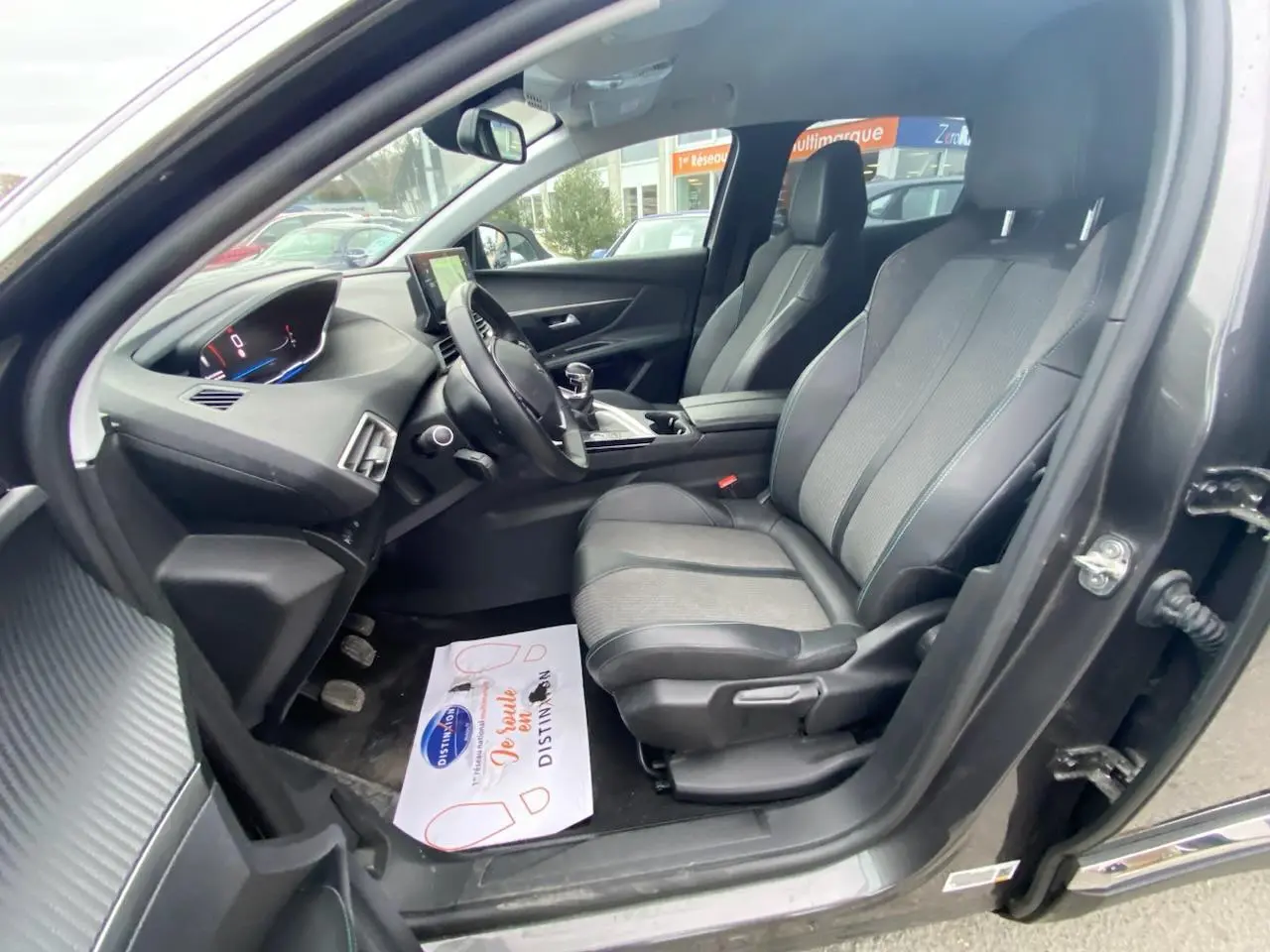 Intérieur avant droit d’un Peugeot 3008 gris platinium 2021, montrant sièges, volant compact et tableau de bord numérique.