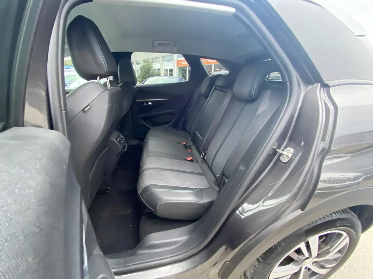 Vue côté droit de l’habitacle arrière du Peugeot 3008 gris platinium, montrant la banquette en cuir et tissu.