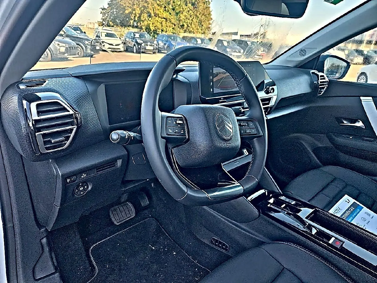 Intérieur noir de la Citroën C4 X 2025 vu côté conducteur, avec volant cuir et écran tactile central.