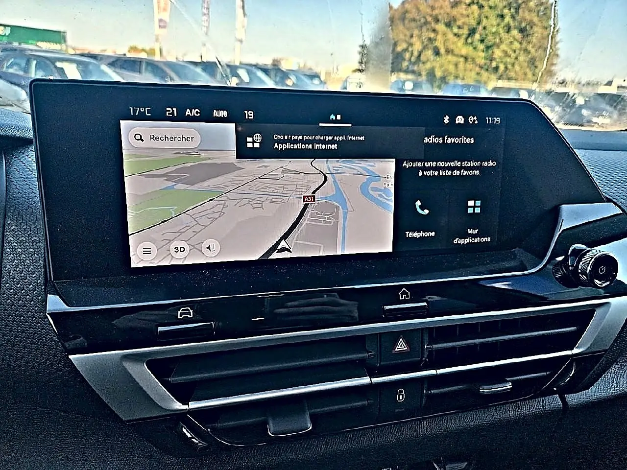 Écran tactile central avec navigation GPS dans l'habitacle du Citroën C4 X hybride blanc, vue de face rapprochée.