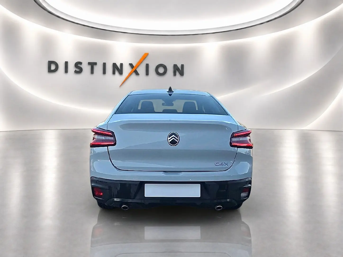 Vue arrière d'une Citroën C4 X blanche 2025 dans un showroom lumineux avec double sortie d'échappement chromée.