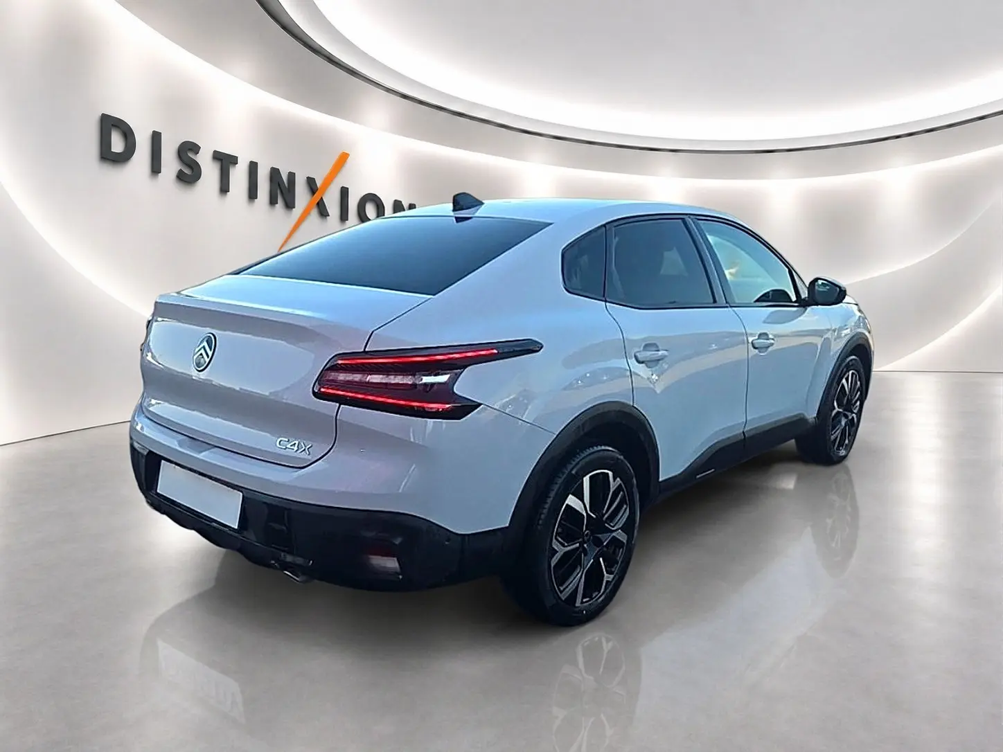 Vue 3/4 arrière droite d'une Citroën C4 X blanche 2025 avec feux arrière LED et jantes alliage noires.