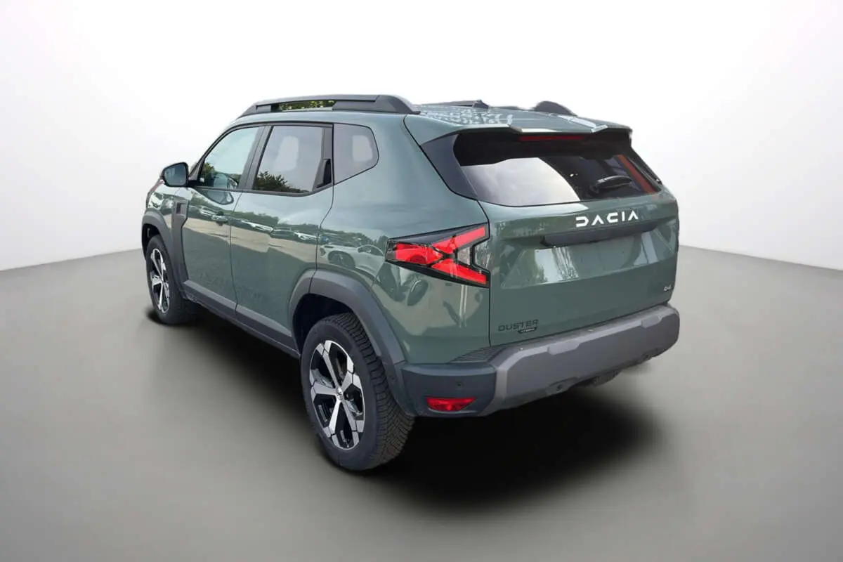 Vue 3/4 arrière droite du Dacia Duster 2026 hybride en kaki lichen avec jantes alu 18 pouces et barres de toit.