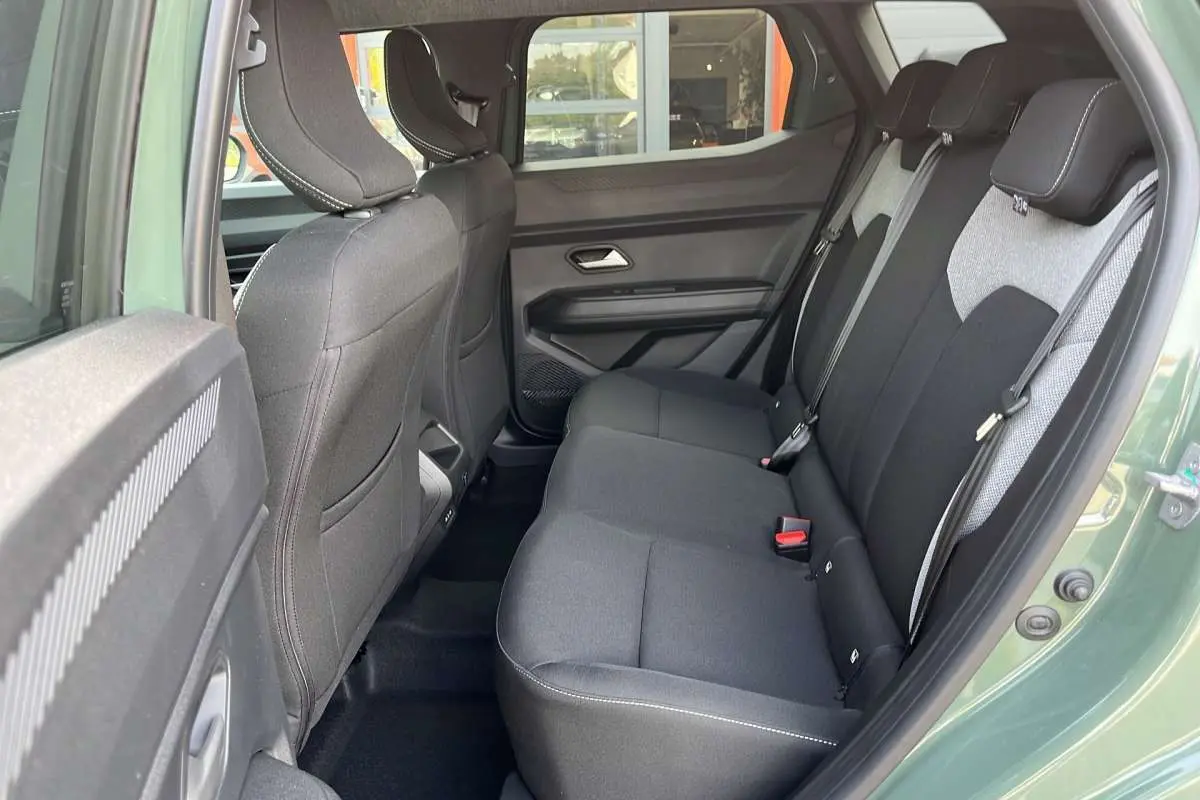 Vue intérieure côté droit sur la banquette arrière noire et grise du Dacia Duster Hybrid-G 150 4x4 couleur kaki lichen.