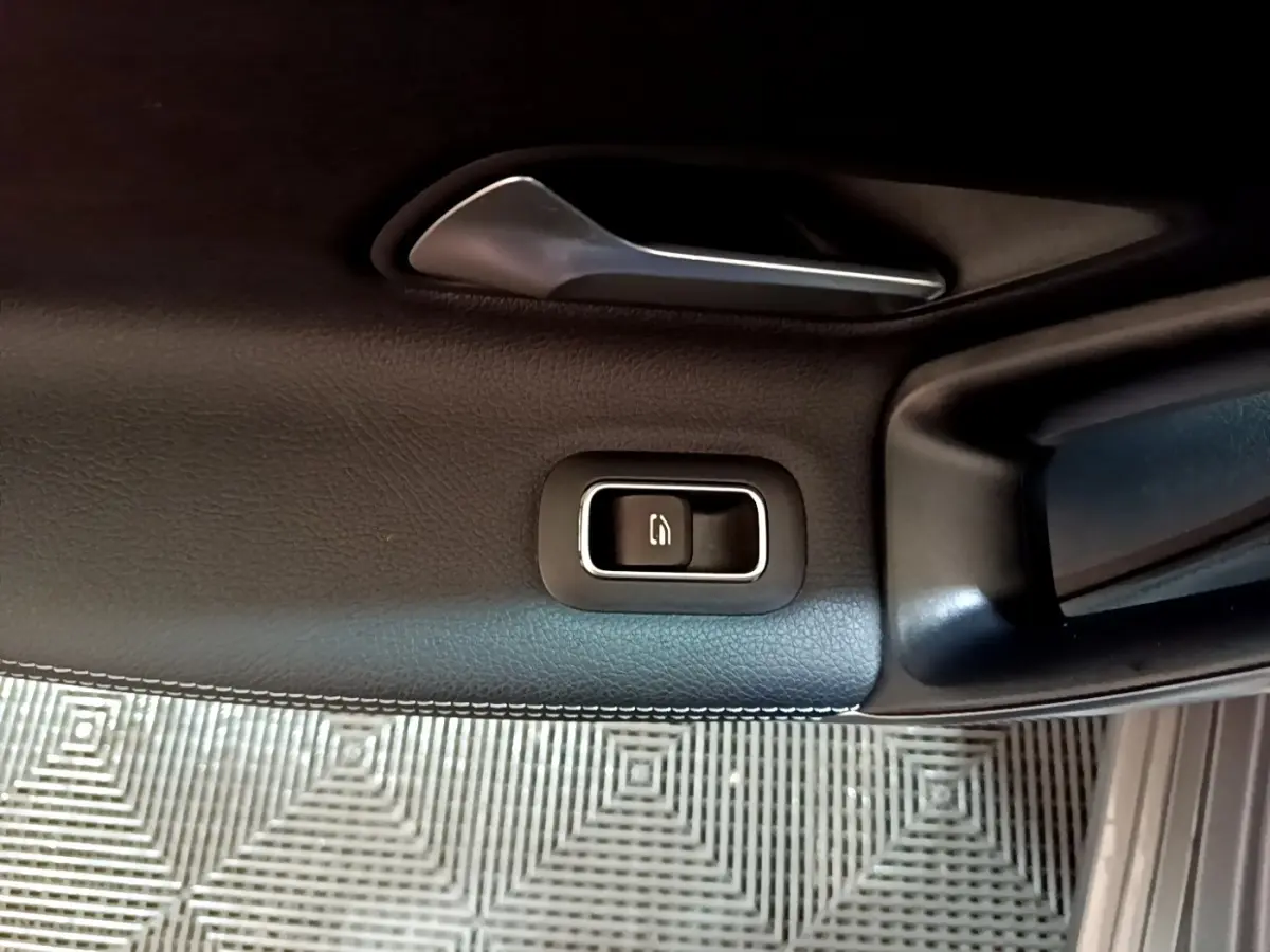 Détail de la commande de verrouillage sur la porte intérieure côté conducteur d’une Mercedes CLA 180 d Business Line gris clair.