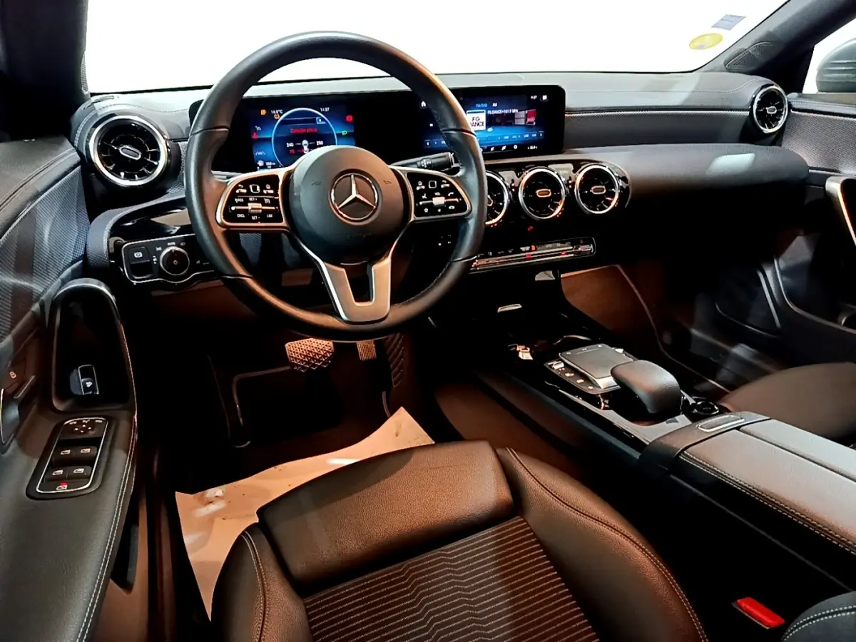 Vue intérieure côté conducteur de la Mercedes CLA 180 d 2021, tableau de bord digital et volant cuir multifonctions.