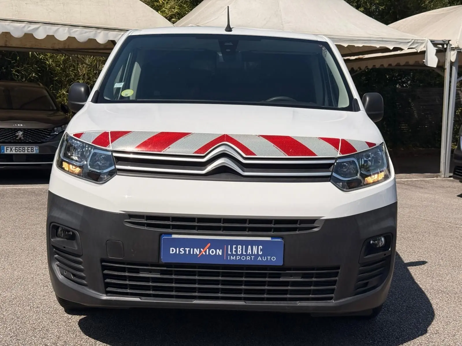 Vue avant d’un Citroën Berlingo blanc 2020 avec bandes réfléchissantes rouges et blanches sur le capot.