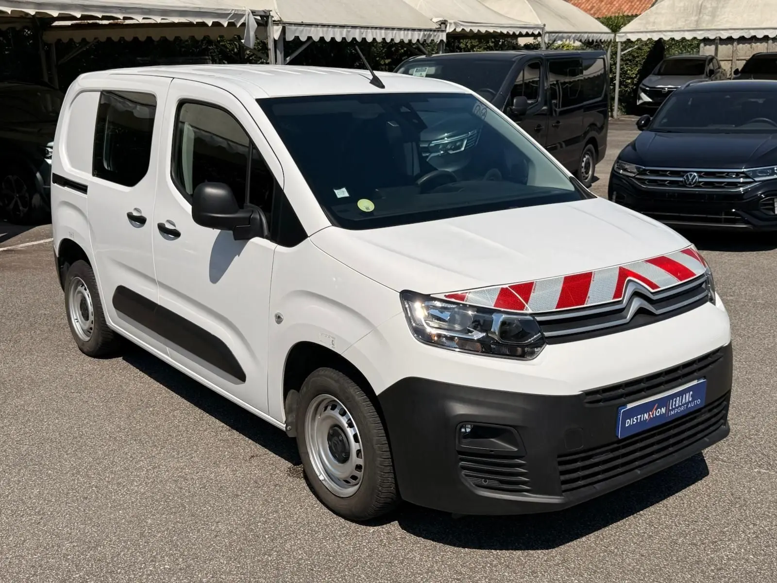 Vue 3/4 avant gauche d’un Citroën Berlingo Van blanc 2020 avec marquage rouge et blanc sur la calandre.