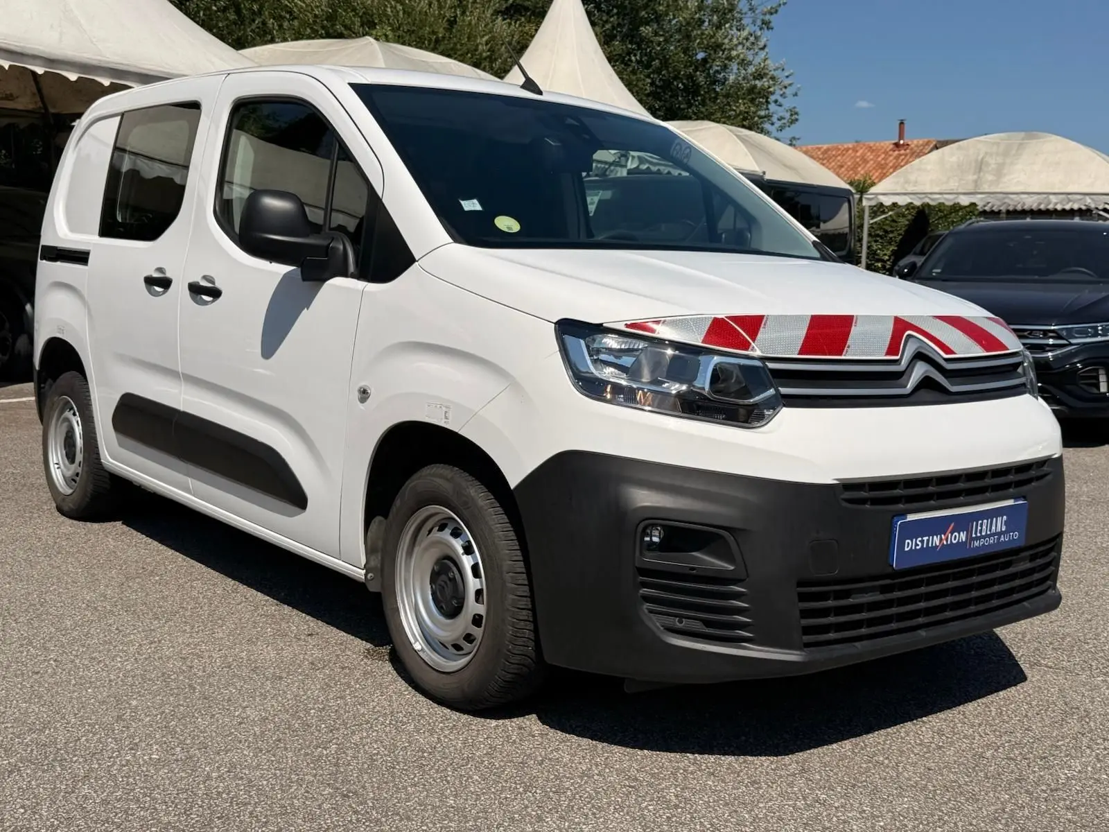 Vue 3/4 avant droit d'un Citroën Berlingo Van blanc 2020 avec marquage rouge et blanc sur le capot et pare-chocs noir.