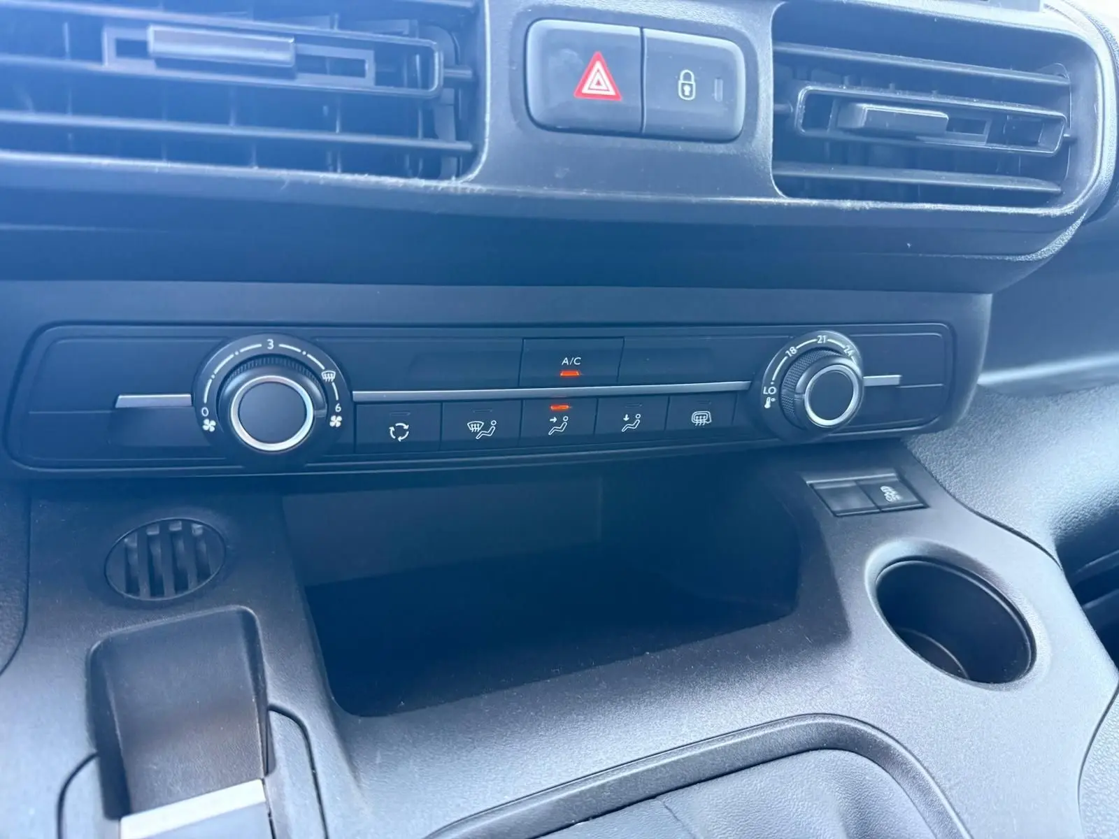 Vue rapprochée du tableau de bord noir du Citroën Berlingo Van 2020, montrant les commandes de climatisation et les aérateurs.