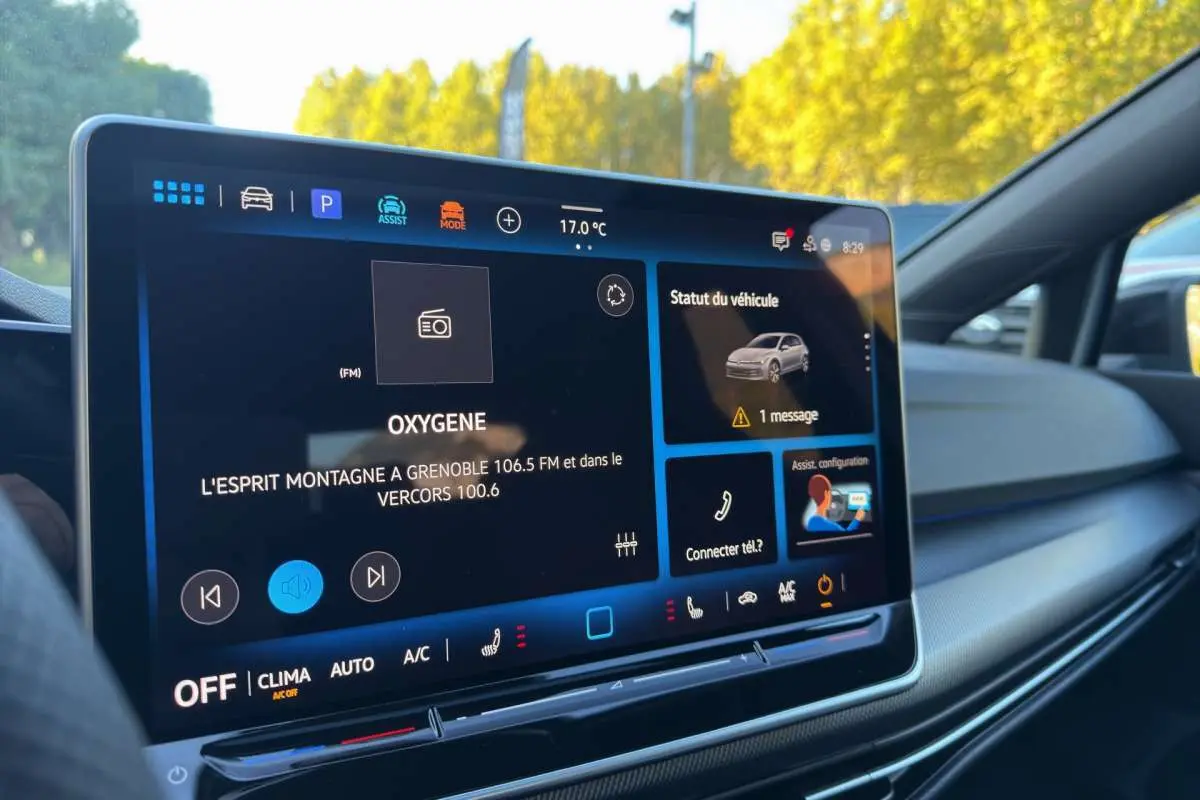 Écran tactile central intérieur de Volkswagen Golf gris argent, affichant radio et statut véhicule.